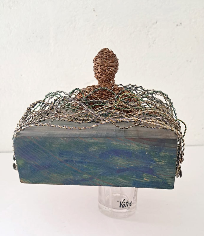 <p><em>Con el agua hasta el cuello</em>. 15X13X10 cm. Madera, alambre de acero, alambre de cobre tejido a mano y perfumero, 2021.</p>